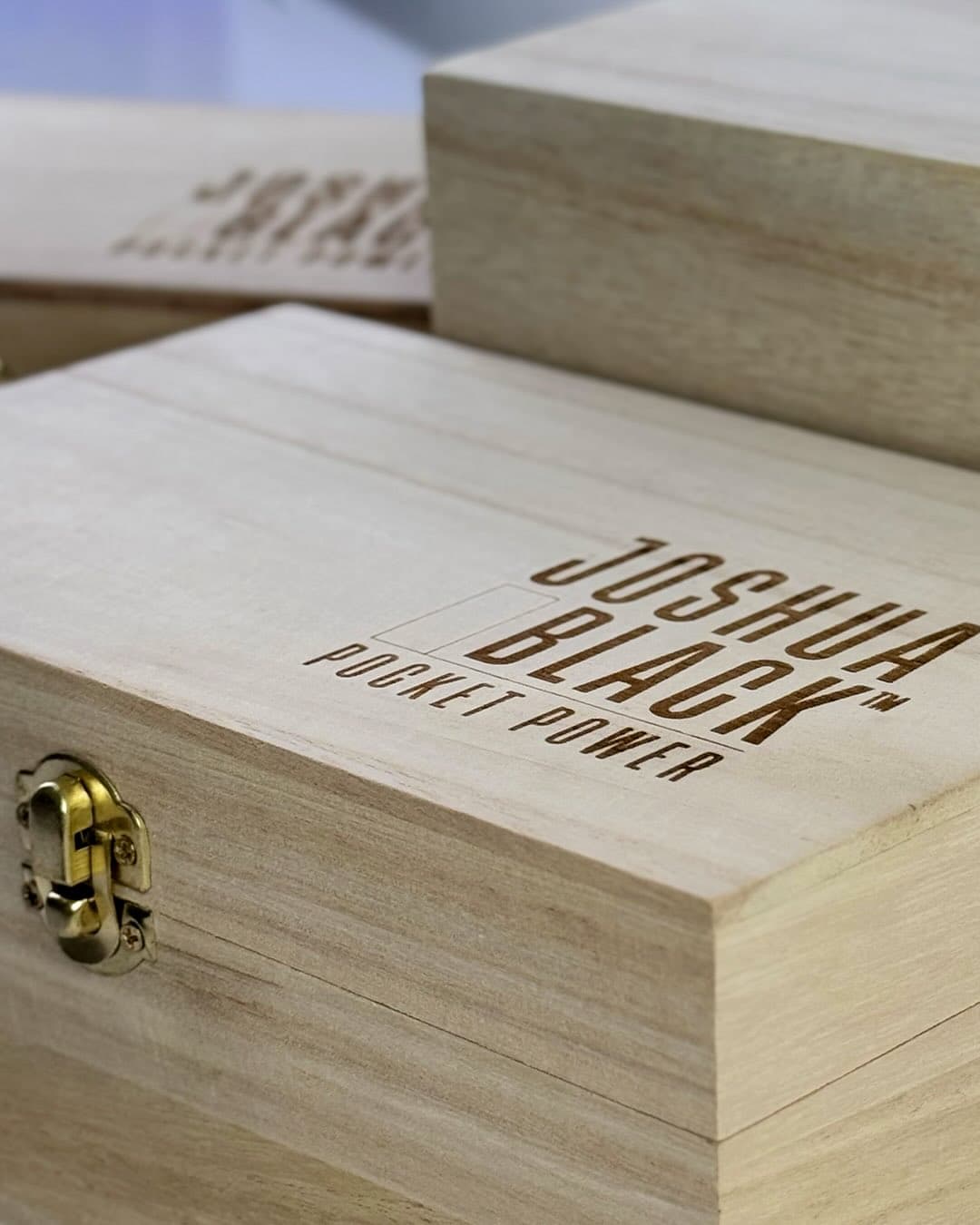 Close view of the Joshua Black Pocket Power engraving on a wooden box lid